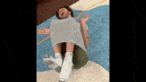 a man is wrapped in a piece of paper and laying on a rug .