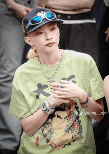 a woman wearing a green t-shirt and a hat has the name gang_ojo on the bottom of her photo