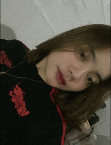 a woman wearing a black shirt with red dragons on the front