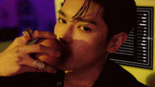 a man with a ring on his finger is biting an apple