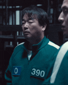 a man in a green jacket has the number 390 on his chest