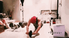 a man in a red hat is doing push ups with a exercise wheel and the word toree is on the bottom