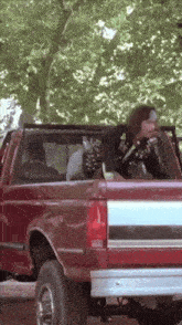 a man sitting in the back of a ford truck