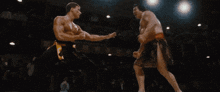 two men are wrestling in a ring and one is wearing a red belt