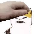 a hand is petting a cartoon character 's head with a hat on .