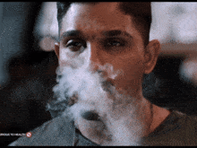 a close up of a man smoking a cigarette with a serious to health sign in the corner
