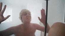 a woman is taking a shower with a shower cap on her head .