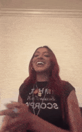 a woman with red hair is wearing a black shirt that says tommy hilfiger