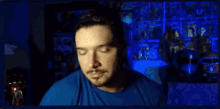 a man in a blue shirt is looking at the camera