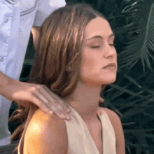 a woman in a white dress is getting a massage from a man .