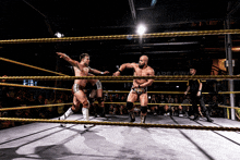 two men in a wrestling ring with the word trade on the wall