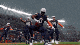 a football player with the number 0 on his jersey is running with the ball