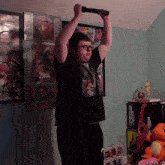 a man in a zelda t-shirt is holding a remote over his head