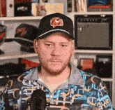 a man with a beard wearing a hat and a shirt with a pattern