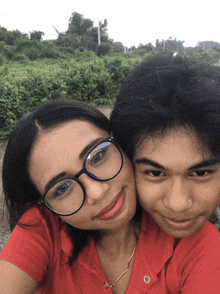 a boy and a girl are posing for a picture and the girl has glasses on