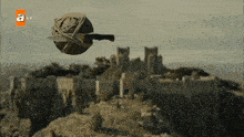 a ball with a knife attached to it is flying over a castle on a tv screen