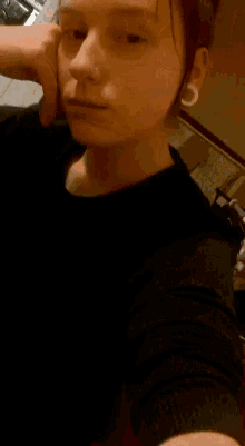 a young girl taking a selfie with her hand on her face