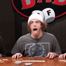 a man wearing a beanie and a shirt that has the letter f on it is playing a board game