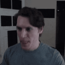 a man in a blue shirt is making a face
