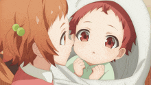 a girl kissing a baby on the cheek