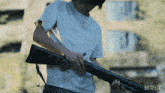 a man in a white shirt is holding a shotgun with a netflix logo in the background