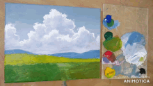 a painting of a cloudy sky next to a palette of paint