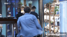 a man in a blue shirt is running in front of a fridge that says star hd on it