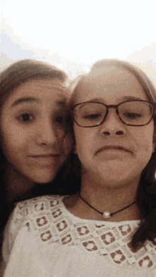 two girls wearing glasses and a choker are posing for a picture together