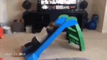 a child is playing on a slide in a living room on may 12 2019 .