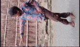 a young man in a plaid shirt is standing on his stomach on the ground .