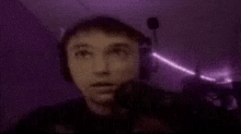 a man wearing headphones is looking up at a purple light .
