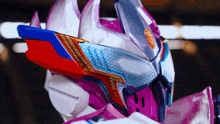 a close up of a robot 's helmet with a red blue and white design