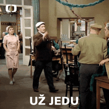 a group of people standing in a room with the word uz jedu written on the bottom