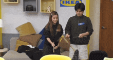 a man and a woman are playing a game in front of a sign that says ikea