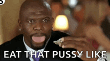 a man in a suit and tie is eating a piece of food and says `` eat that pussy like '' .