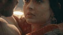 a close up of a woman 's face with a man 's arm around her shoulder .