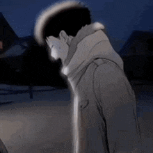 a man in a trench coat is standing in the dark .