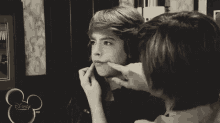a black and white photo of two boys giving the middle finger .