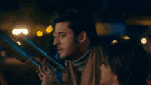 a man wearing a turtleneck and scarf looks at something