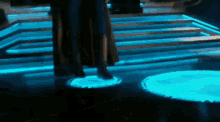a person is standing on a platform with blue lights
