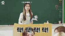 a group of girls are sitting at desks in a classroom with the letters twice on the wall behind them