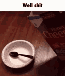 a bowl of cereal with a spoon in it next to a box of honey bunches of oats