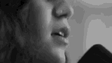 a close up of a woman 's face singing into a microphone .