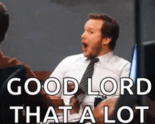 a man in a suit and tie is sitting in a chair with his mouth open and says `` good lord that a lot ''