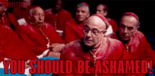a group of cardinals are sitting in a dark room with the caption " you should be ashamed " above them