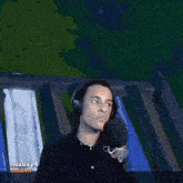 a man wearing headphones is pointing at a sign that says relancer une parte