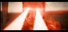 a close up of a man 's face with two red lights coming out of his eyes .