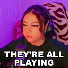 a woman wearing headphones is sitting in front of a computer screen .