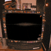 a samsung television with stickers on it and a monster energy drink