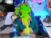 a woman is sitting in front of a microphone with green liquid coming out of her face